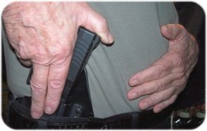 Inserting Into the Holster. Two Fingers Cover Trigger Guard As Holster Is Inserted